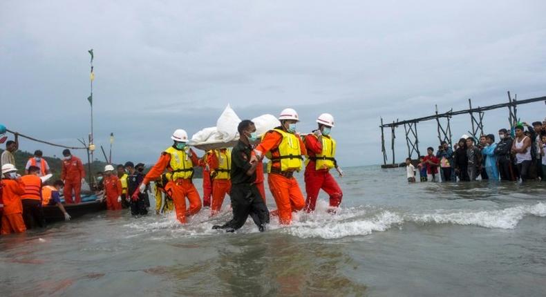 Hundreds of people gathered solemnly on a beach in southern Myanmar awaiting news of their loved ones as rescuers worked to pull bodies from the Andaman Sea after a military plane crashed with more than 120 people on board