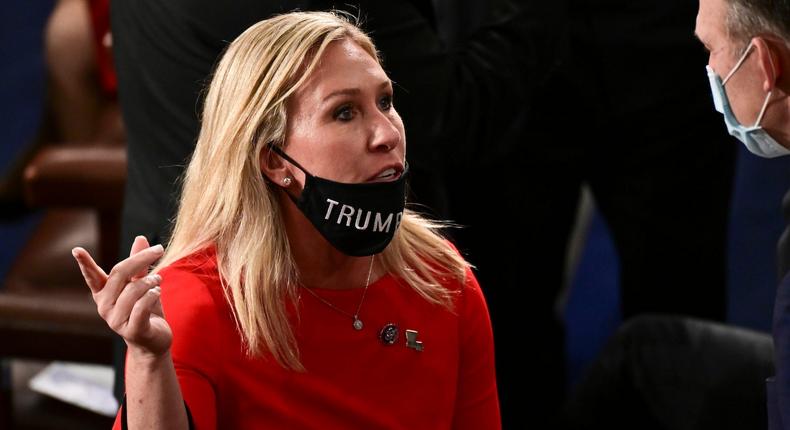 Rep. Marjorie Taylor Greene is seen with her face mask pulled down as she speaks with a colleague on the floor of the House on January 3, 2021 for the swearing in of the new Congress.