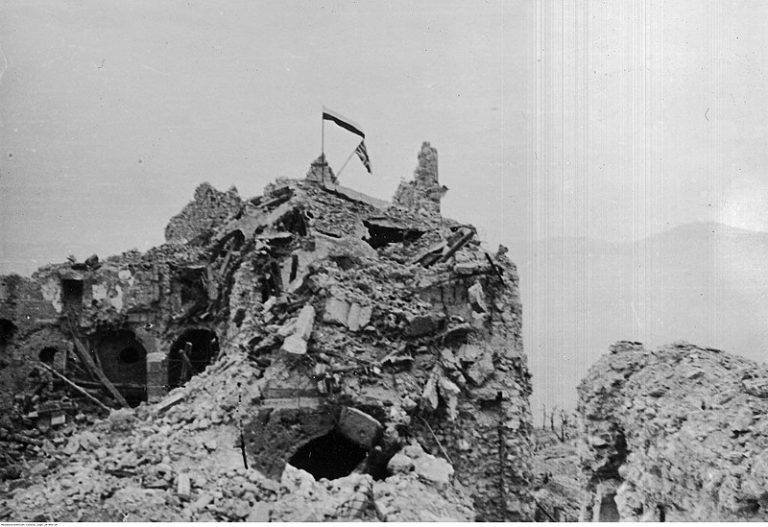 Flagi polska i brytyjska powiewające nad ruinami klasztoru na Monte Cassino.