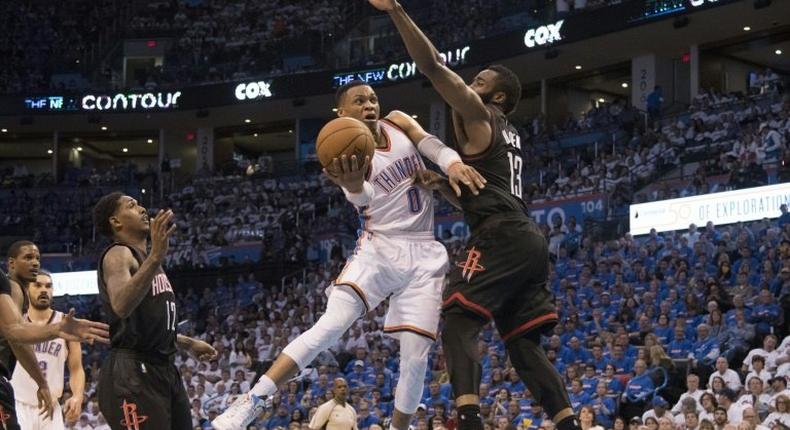 Russell Westbrook of the Oklahoma City Thunder drives around James Harden of the Houston Rockets during Game Three in the Western Conference Quarterfinals