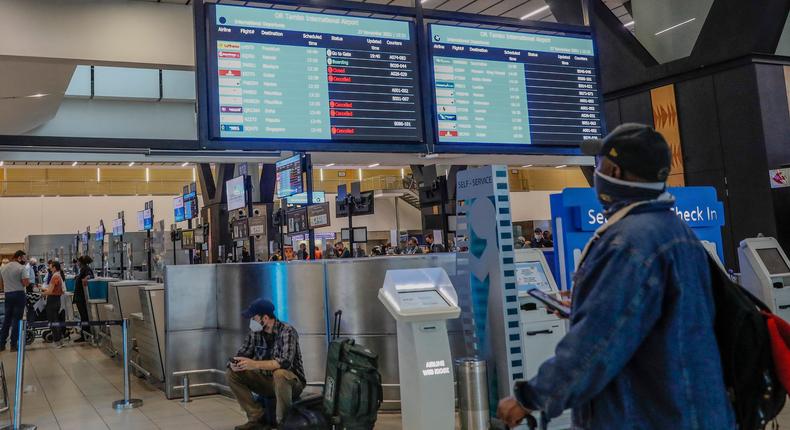 A passenger looks at an electronic flight notice board displaying cancelled flights at Tambo International Airport in Johannesburg on November 27, 2021, after several countries banned flights from South Africa following the discovery of a new coronavirus variant Omicron.