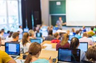 44192156 - rear view of students sitting and listening in lecture hall doing practical tasks on thei