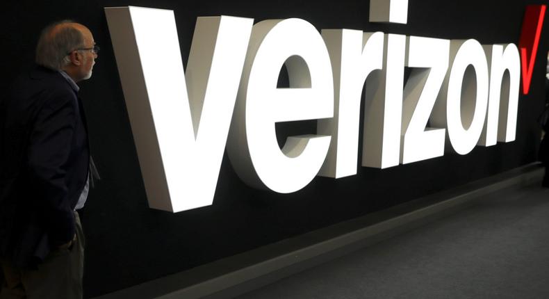 FILE PHOTO: A man stands next to the logo of Verizon at the Mobile World Congress in Barcelona, Spain, February 26, 2019. REUTERS/Sergio Perez