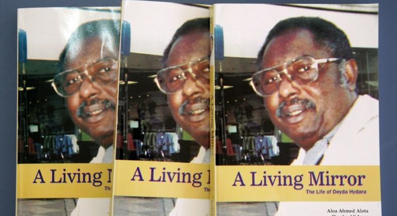 Two fugitive former army officers have been indicted over the 2004 murder of prominent Gambian journalist Deyda Hydara, shown here on the cover of a book on his life