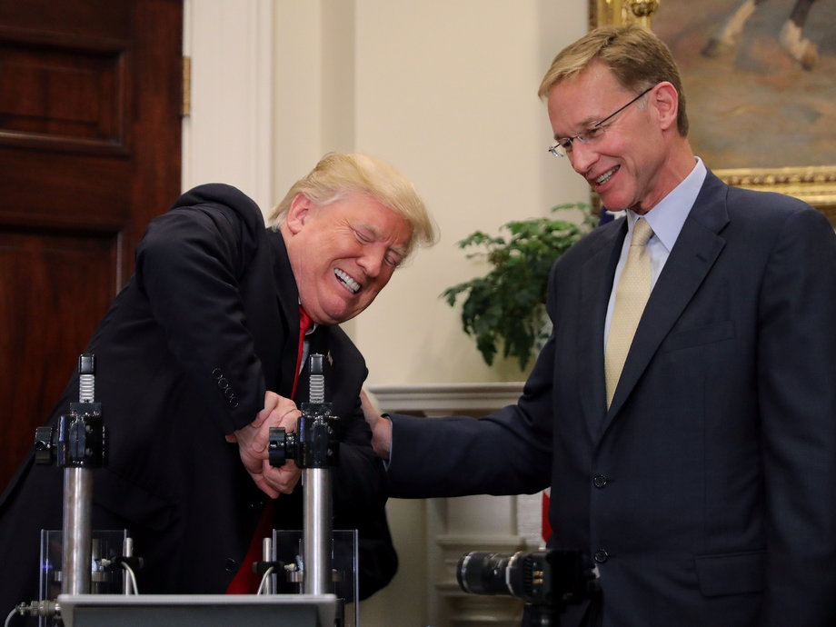 U.S. President Donald Trump participates in a strength vial test accompanied by Corning Pharmaceutical Glass Chairman and CEO Wendell Weeks during a "Made in America" event on pharmaceutical glass manufacturing, at the Roosevelt Room of the White House in Washington, U.S., July 20, 2017.