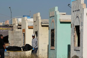 Forensic technicians remove a body from a crime scene where unidentified assailants killed and injured people living in a house at Riberas del Bravo neighbourhood, in Ciudad Juarez