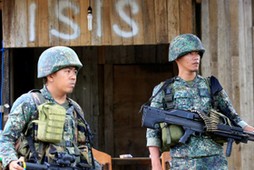 Soldiers stand guard along the main street of Mapandi village as government troops continue their as