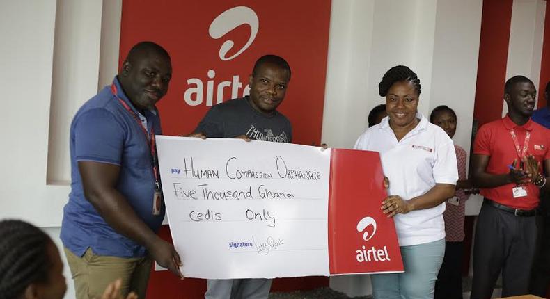 Maruf Lawal, Networks & IT Director (middle) assisted by Kwame Annor (Left) – Human Resource Business Partner, Airtel to make the presentation  to Ms. Angela Jones (Right), representative of the Orphanage