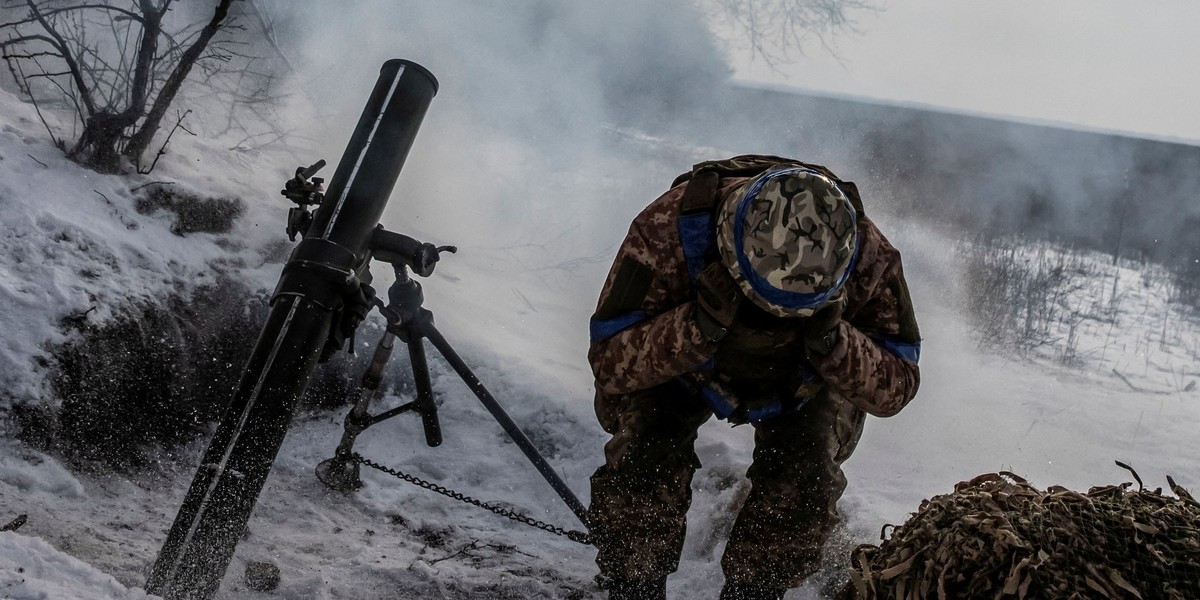 Ukrainian servicemen sit atop a BMP-2 infantry fighting vehicle on a road outside the frontline town