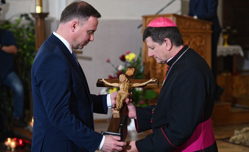 Prezydent Andrzej Duda (L) przekazuje na ręce ordynariusza diecezji łuckiej biskupa Witalija Skomarowskiego (P) pamiątkowy krzyż poświęcony pamięci pomordowanych Polaków