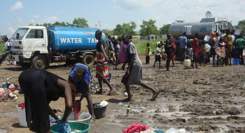 This handout photo provided by the United Nations Mission in the Republic of South Sudan (UNMISS) and released on July 16, 2016 shows women doing laundry as people collect water at the UN compound in the Tomping area in Juba 