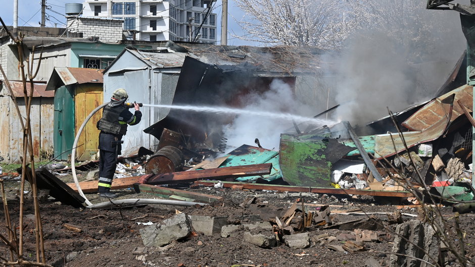 Strażacy gaszą pożar po uderzeniu rosyjskiej rakiety w centrum Charkowa