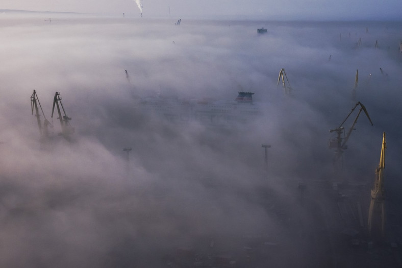 Żurawie Stoczni Szczecińskiej wyłaniają się z mgły nad Odrą. Zdjęcie zrobione z najwyższej suwnicy w Europie. Szczecin, 2016 r.