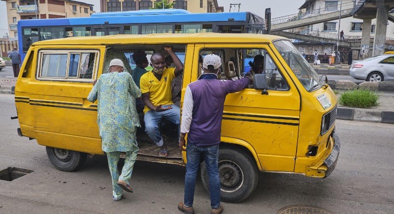 A Lagos bus driver places the mask below his nose as he 'shadows' passengers (Pulse)