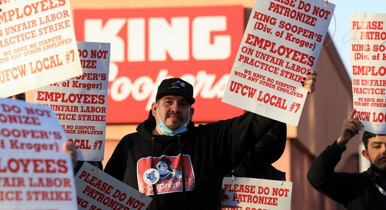 Union members raise signs outside a King Soopers store during a protest as workers go on strike in Denver, Colorado, U.S., January 12, 2022.