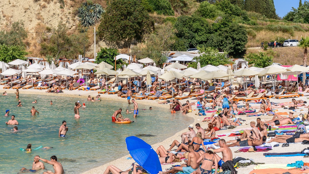 Davy ľudí opaľujúcich sa a relaxujúcich na pláži Kašjuni v meste Split v Chorvátsku. 