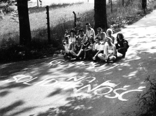 Grupa młodzieży pozuje przy haśle Głosuj na Solidarność . Zachełmie, 1989 r. (fot. MOs810, opublikowano na licencji Creative Commons Uznanie autorstwa-Na tych samych warunkach 4.0 Międzynarodowe).