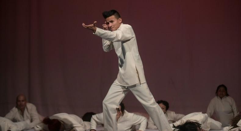 A former member of an armed group, Dereck Anderson (C), performs during the Victus II Memory theater project, in Bogota on May 11, 2017