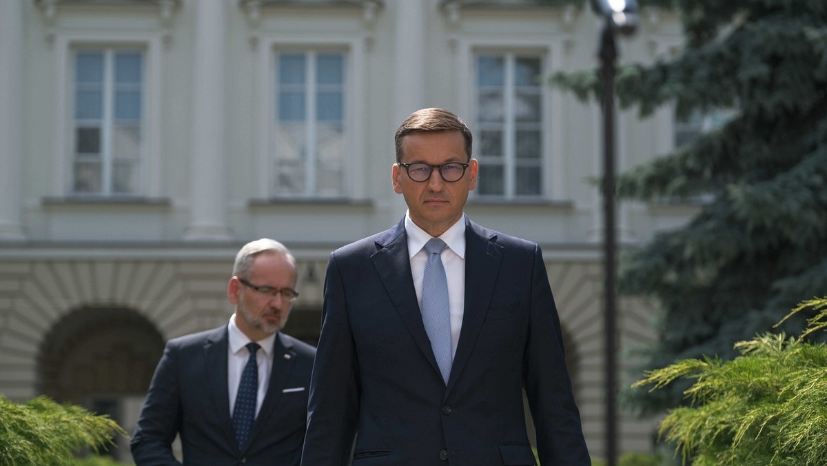 Premier Mateusz Morawiecki (P) oraz minister zdrowia Adam Niedzielski (L) podczas konferencji prasowej przed Ministerstwem Zdrowia w Warszawie