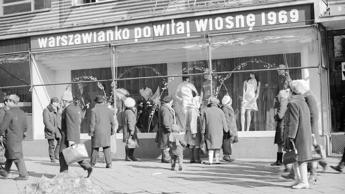 Przechodnie przed sklepem "Paulinka". Widoczny szyld "warszawianko powitaj wiosnę 1969"