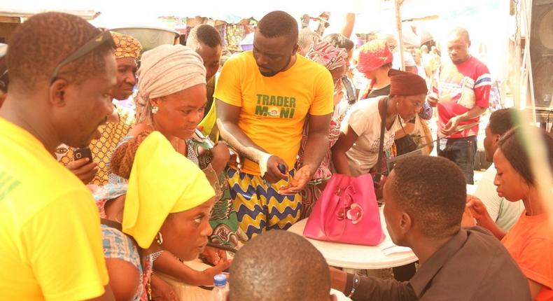 Traders at Oyingbo Market being attended to by the activation agents during the inauguration of TraderMoni across three makets in Lagos on Tuesday