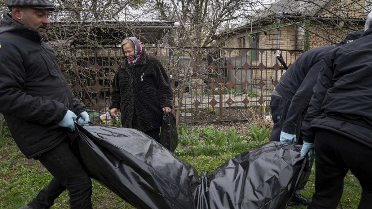 Wład Minczenko, z lewej, niesie zwłoki Stanisława Berestnewa, który zginął podczas rosyjskiej inwazji i został pochowany na cmentarzu w Buczy w Ukrainie we wtorek 19 kwietnia 2022 r. 