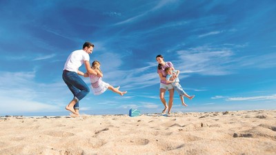 Parents Swinging Children at the Beach