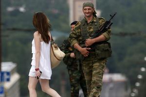An armed man smiles at a girl