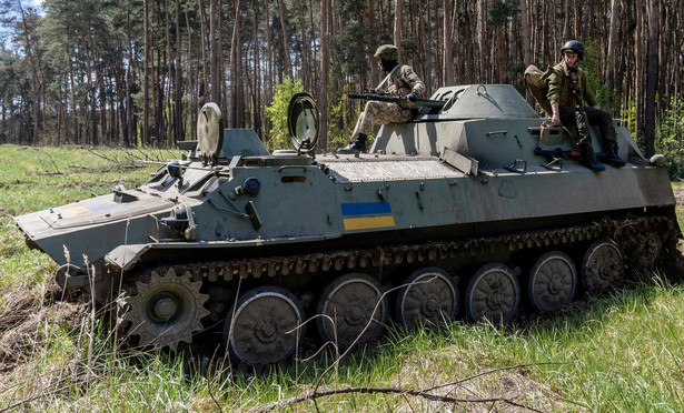 Żołnierze Gwardii Narodowej Ukrainy i transporter opancerzony MT-LB na posterunku wojskowym na obrzeżach Charkowa