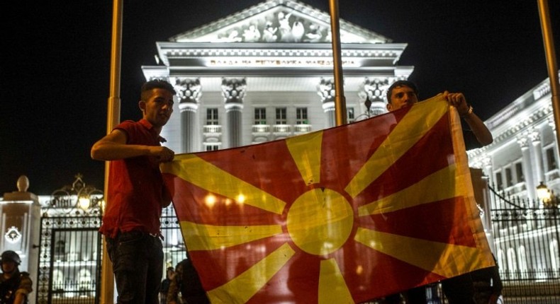 Protesters wave a Macedonian flag in front of the government building in Skopje on April 18, 2016, during a protest against the president's shock decision to halt probes into more than 50 public figures embroiled in a wire-tapping scandal