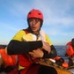 Spanish rescuer Daniel Calvelo carries a four-day-old baby girl into a RHIB, during a search and res