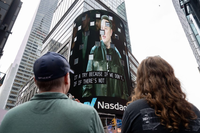 Posmatrači gledaju kako se na ekranu na Tajms skveru pojavljuje Ilon Mask, osnivač kompanije SpaceX, tokom inicijalne javne ponude akcija (IPO) kompanije u Nasdaq MarketSite centru, 12. juna 2026. godine u Njujorku.