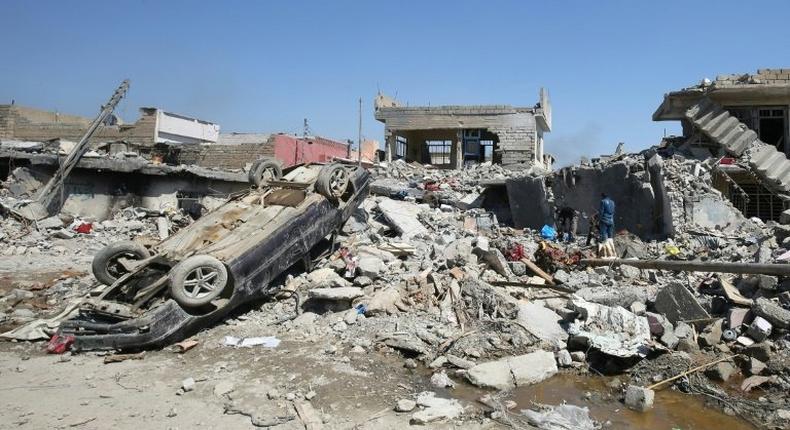 Iraqis inspect the rubble of destroyed houses in the Mosul al-Jadida area, following air strikes in March 2017