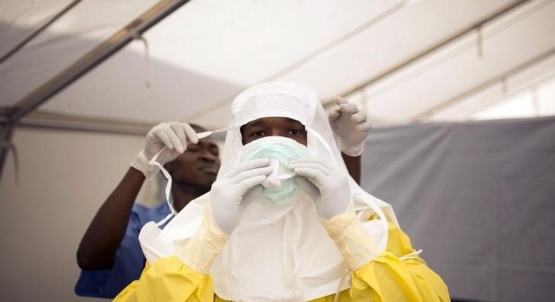 Health workers put on protective gear before entering a quarantine zone at a Red Cross facility in the town of Koidu, Kono district in Eastern Sierra Leone December 19, 2014. 
   REUTERS/Baz Ratner