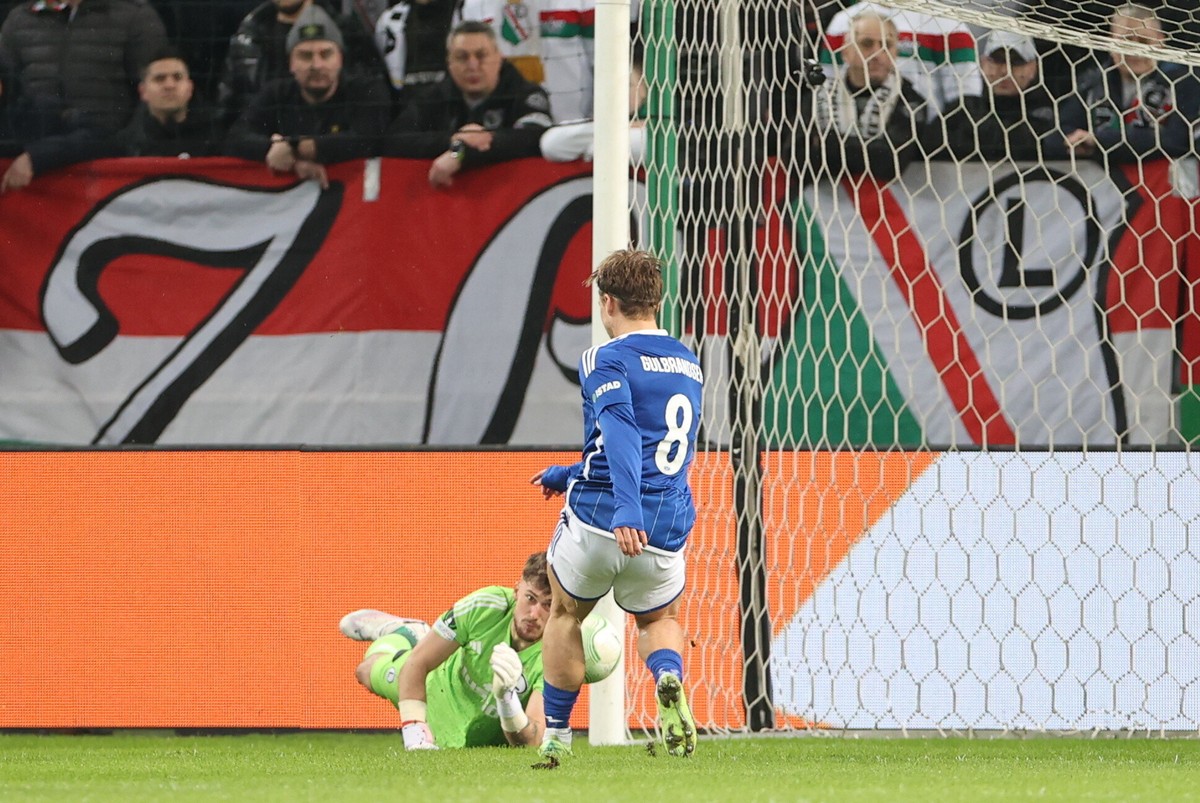 Zawodnik Molde FK Fredrik Gulbrandsen (P) strzela gola podczas drugiego meczu play off o awans do 1/8 finału piłkarskiej Ligi Konferencji Legią Warszawa