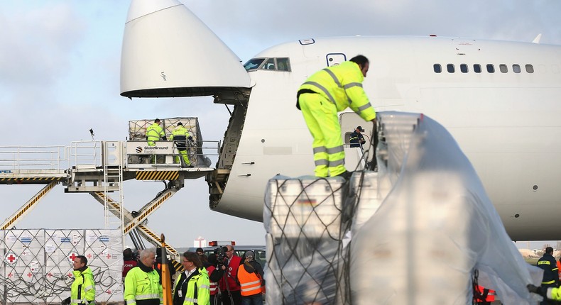 Workers load a shipment of cargo onto a flight.