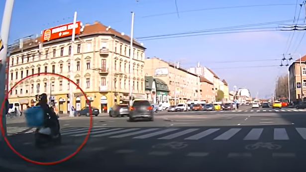 A piros lámpával mit sem törődve hajtott a forgalmas kereszteződésbe egy robogós futár Budapesten: durva baleset lett a vége – videó