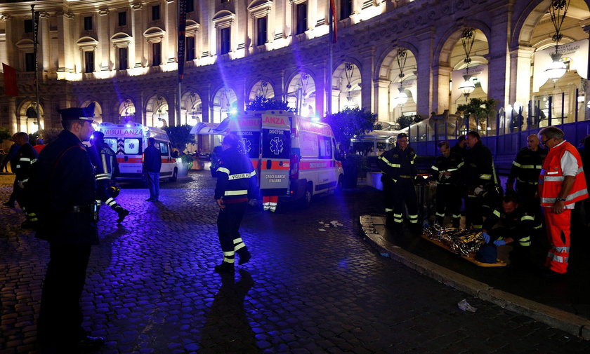 Fire fighters and medical staff member carry an injured person outside the underground where some of