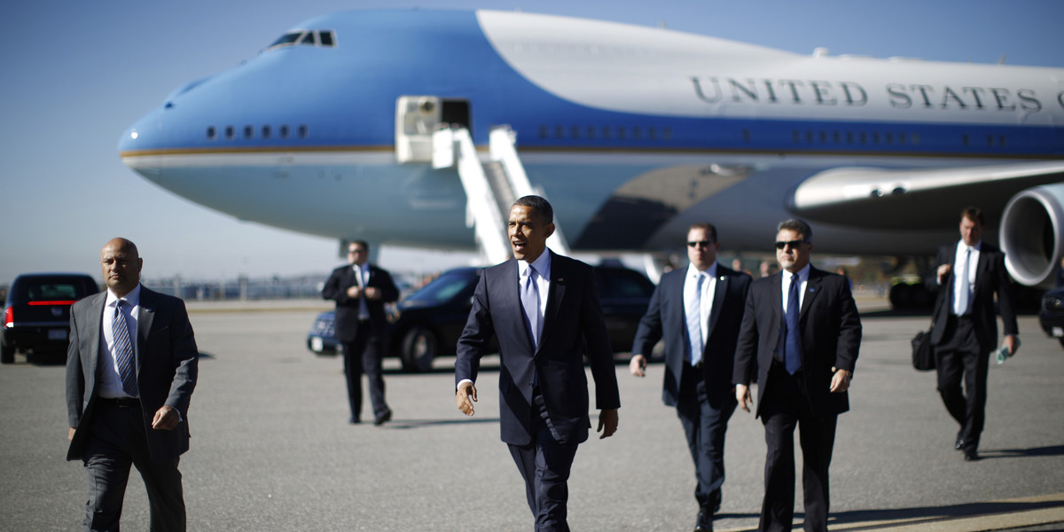 US President Barack Obama walks with Secret Service agents from Air Force One upon his arrival in Manchester, New Hampshire, October 18, 2012.