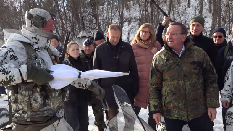 Żołnierz Bundeswehry pokazuje biały parasol ministrowi obrony Niemiec Borisowi Pistoriusowi