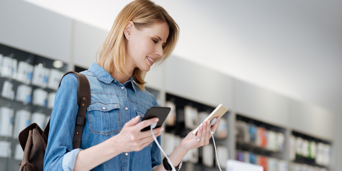 Pretty female shopper comparing mockup phones at store