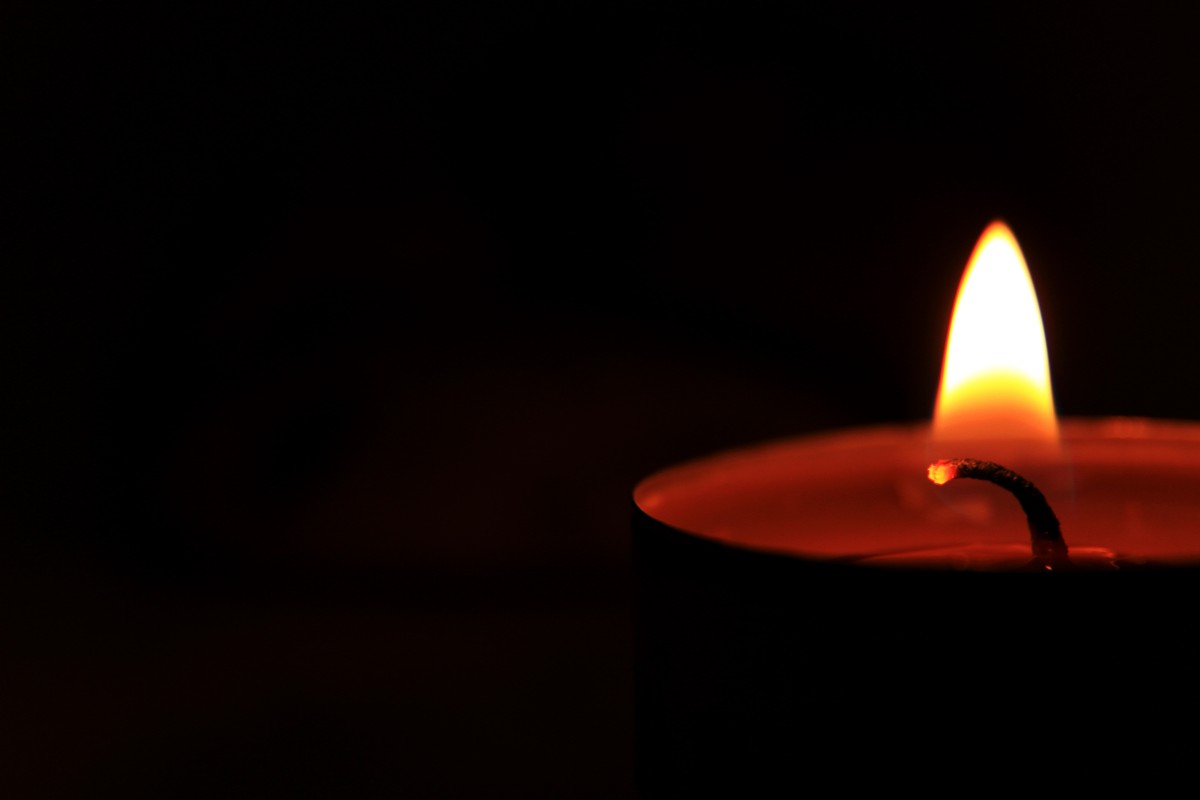 Brightly,Burning,Candle,On,A,Black,Background