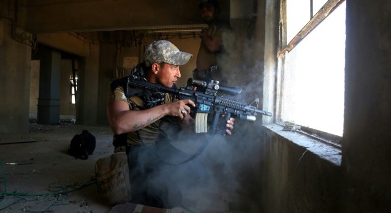 A member of the elite Counter-Terrorism Service fires on Islamic group fighters in the Shuhada neighbourhood as goverment forces advance in west Mosul on March 10, 2017