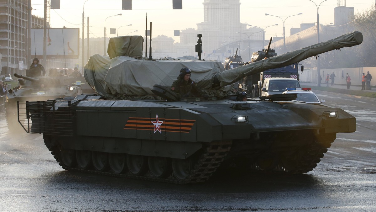 Russian servicemen drive a partially covered T-14 Armata tank along a street before a rehearsal for the Victory Day parade in Moscow