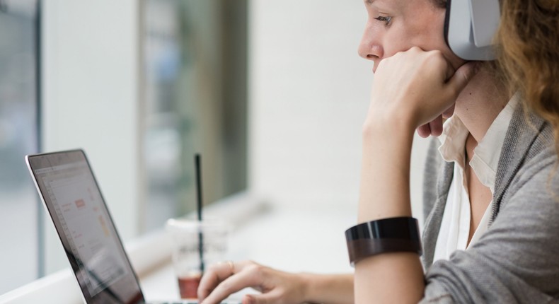 woman using mac laptop headphones