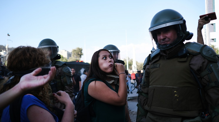 Az egyik tüntető asszony az orális szexre utaló egyezményes jellel üzent szemtől szembe az egyik rohamrendőrnek. /Fotó: Getty Images