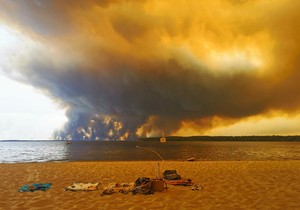 Posetioci plaže odmaraju se na plaži Mučik na obali jezera Lakano u Lakanou, na jugozapadu Francuske, dok požar besni u Žirondi, 24. jul 2026.