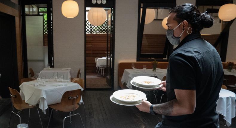 A waiter delivers food to a table at Bottino Restaurant in Chelsea as New York City restaurants open for limited capacity indoor dining on October 1, 2020 in New York.