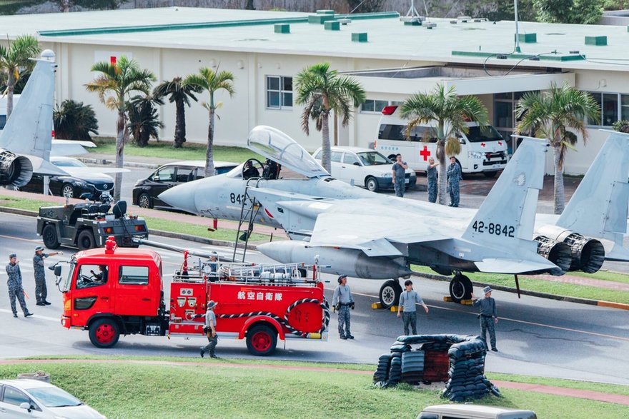 Myśliwiec F-15J podczas holowania ulicami miasta Naha. Przejazd zabezpiecza straż pożarna i służby medyczne