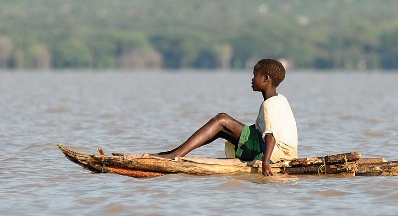 A boy floats on a locally made canoe across Lake Baringo. (eastafricanjunglesafaris.)